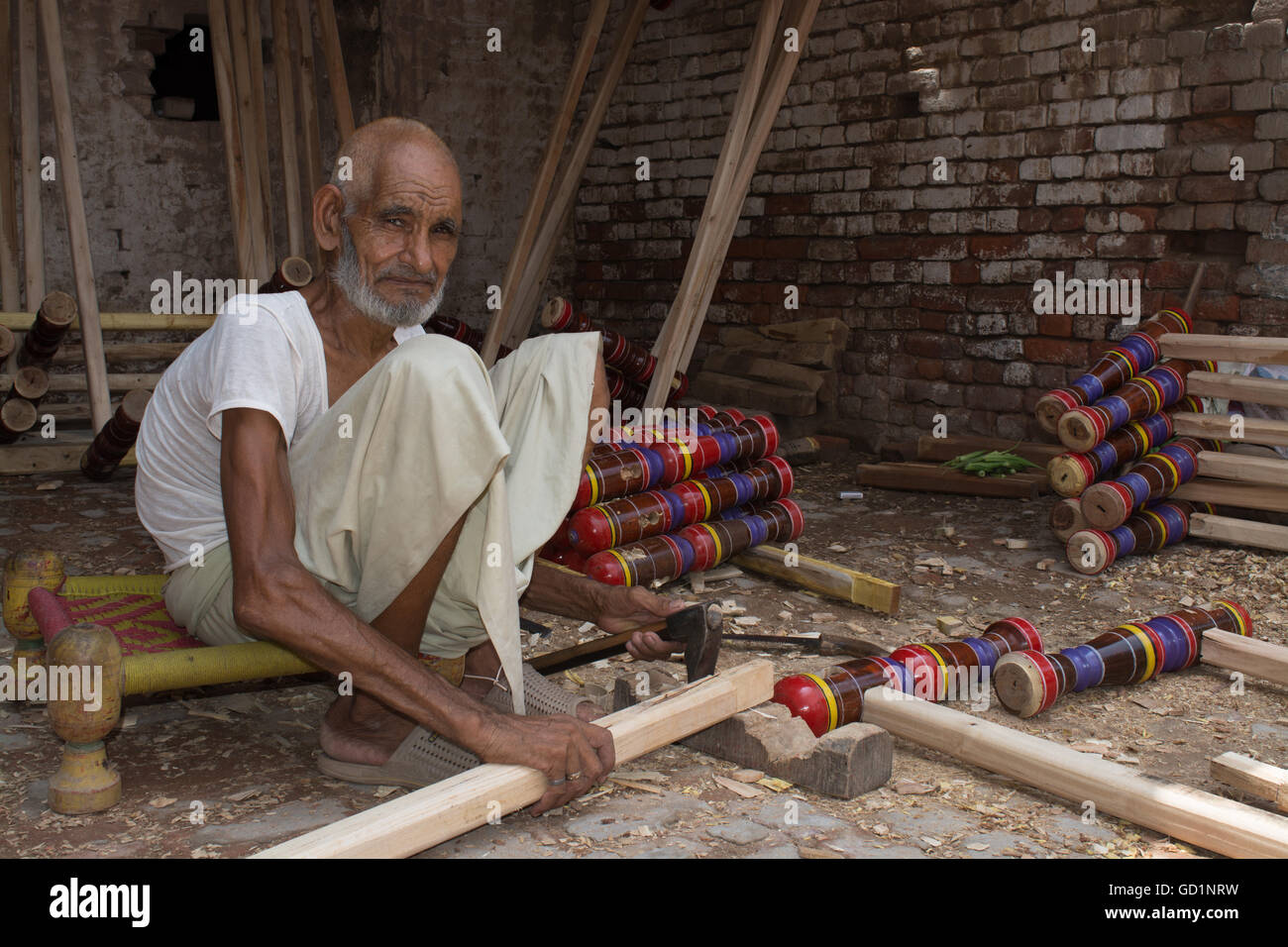 Un viejo hombre por encima de 100 años de antigüedad está trabajando en un taller de elaboración de literas en ciudad de Pindi Bhattian, Punjab, Pakistán. Foto de stock