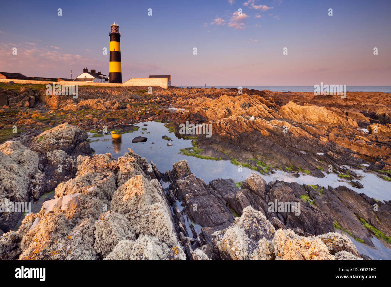 El Saint John's Point Lighthouse en Irlanda del Norte fotografiado al atardecer. Foto de stock