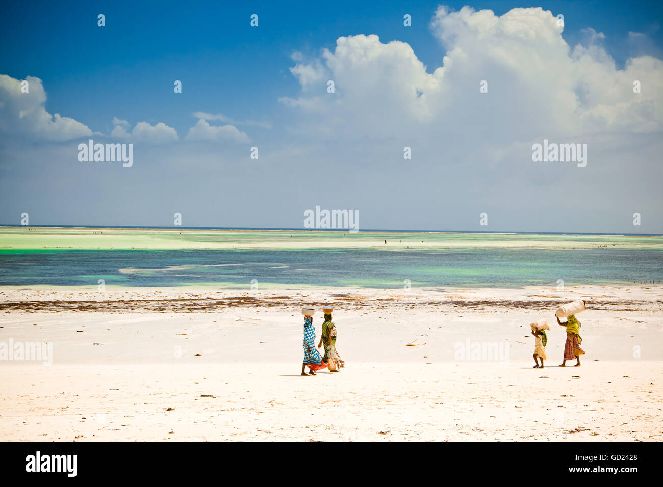Las mujeres africanas caminando por la playa, la isla de Zanzíbar, Tanzania, África oriental, África Foto de stock
