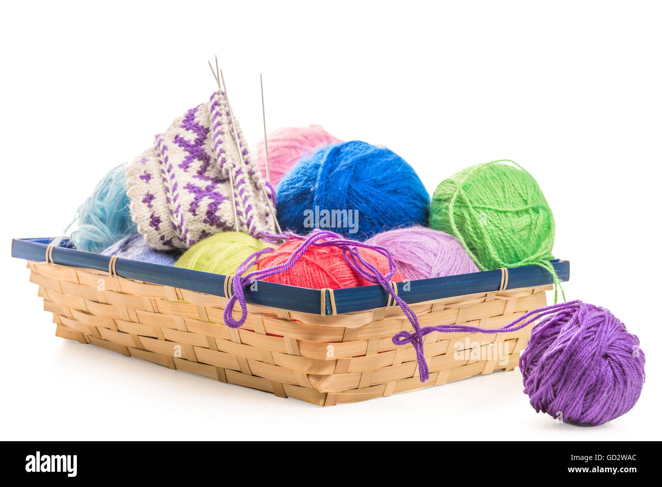 Parte de los calcetines de lana hechas a mano en la canasta con hilo Foto de stock