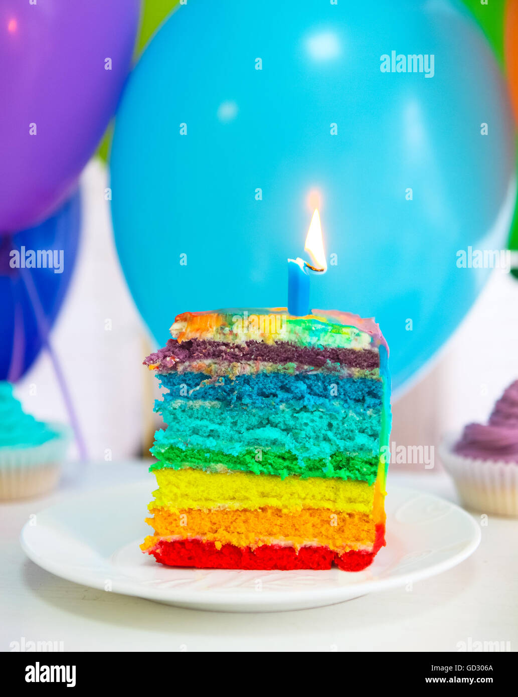 Rainbow cake decorado con velas de cumpleaños. Globos en el fondo  Fotografía de stock - Alamy