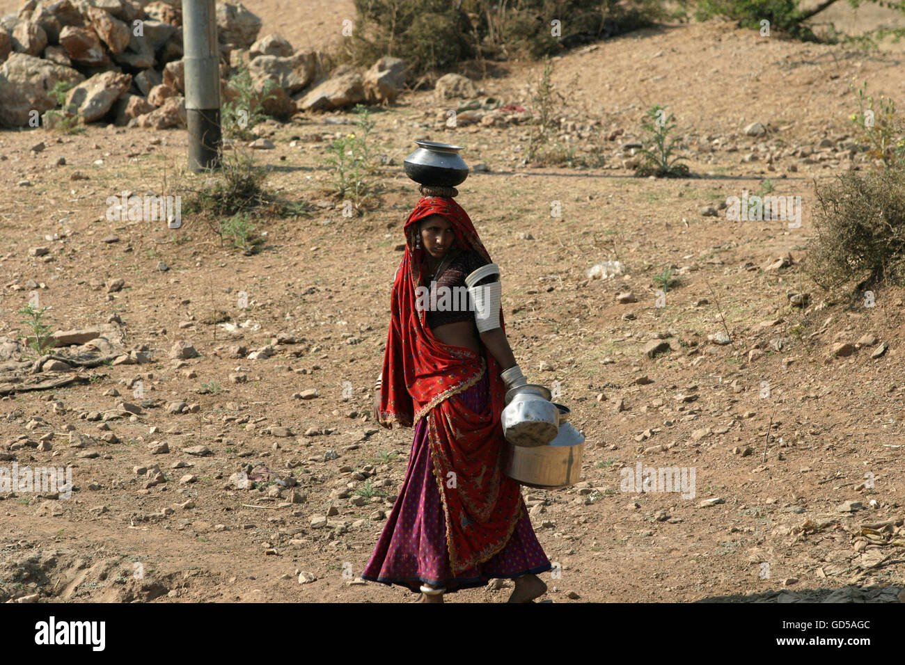 Mujer en su camino a buscar agua Foto de stock