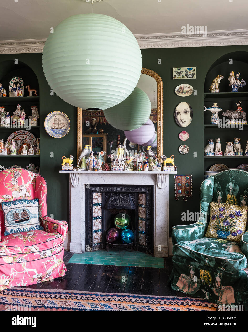 Dibujo ecléctica habitación pintada en Sherwood verde por Farrow & Ball. Stafforshire Fornasettie placas, figuras y piezas de David C Foto de stock