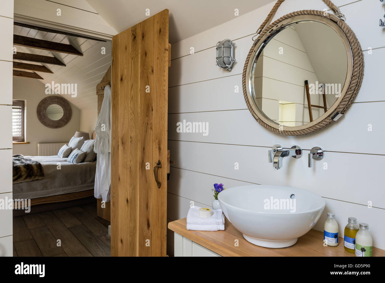 Tablones de madera pintada de blanco y estilo náutico espejo en el cuarto de baño Foto de stock