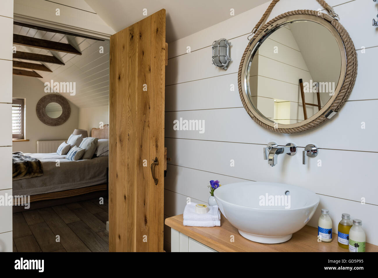 Tablones de madera pintada de blanco y estilo náutico espejo en el cuarto de baño Foto de stock