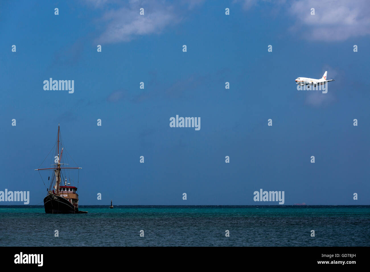 Avión comercial de pasajeros en el aeropuerto internacional de Aruba, con  botes de pesca y mar azul, Surfside Beach Fotografía de stock - Alamy
