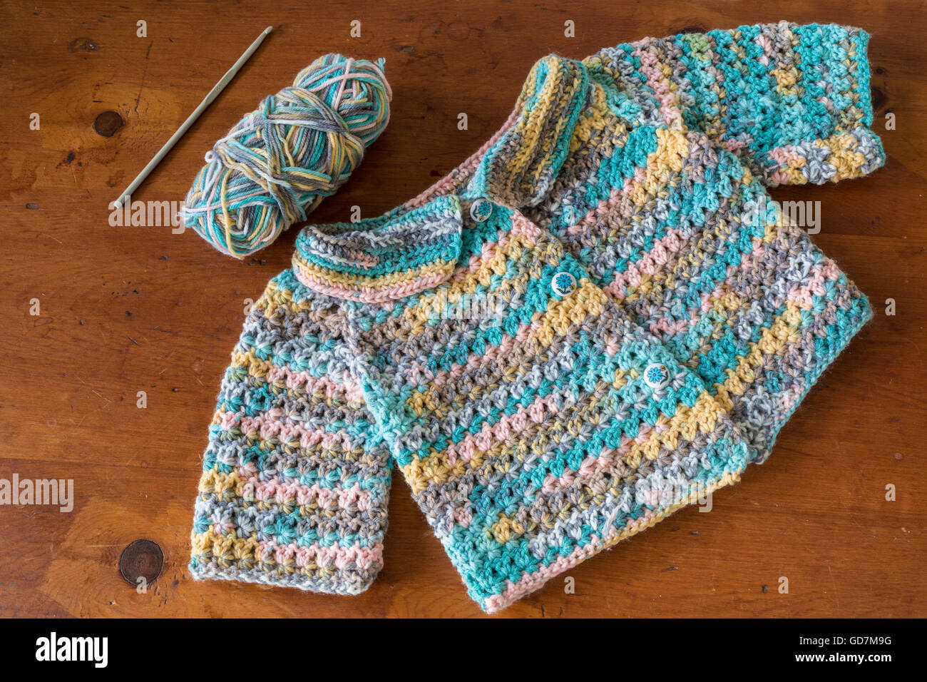 Crochet suéter de bebé con un gancho de ganchillo y la madeja de hilo  Fotografía de stock - Alamy