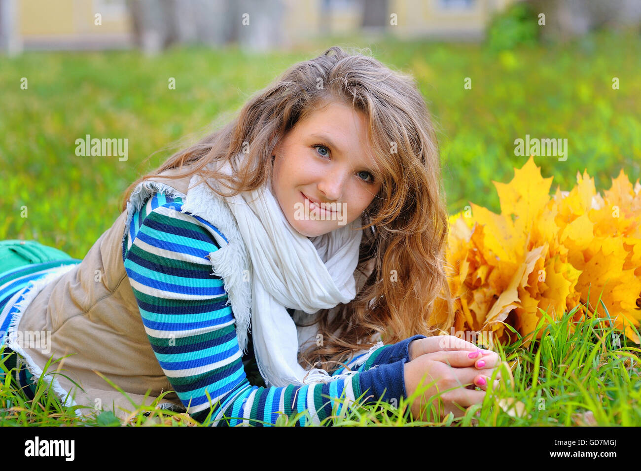 Mujer joven con hojas de otoño en la mano y caída de arce amarillo gar Foto de stock