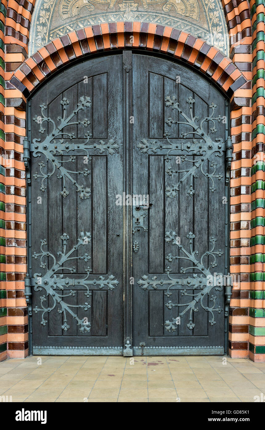 Iglesia de madera masiva con un asa de la puerta con una mano de hierro forjado asentado en un muro de ladrillo en la iglesia. Breclav. Sur Moravi Foto de stock