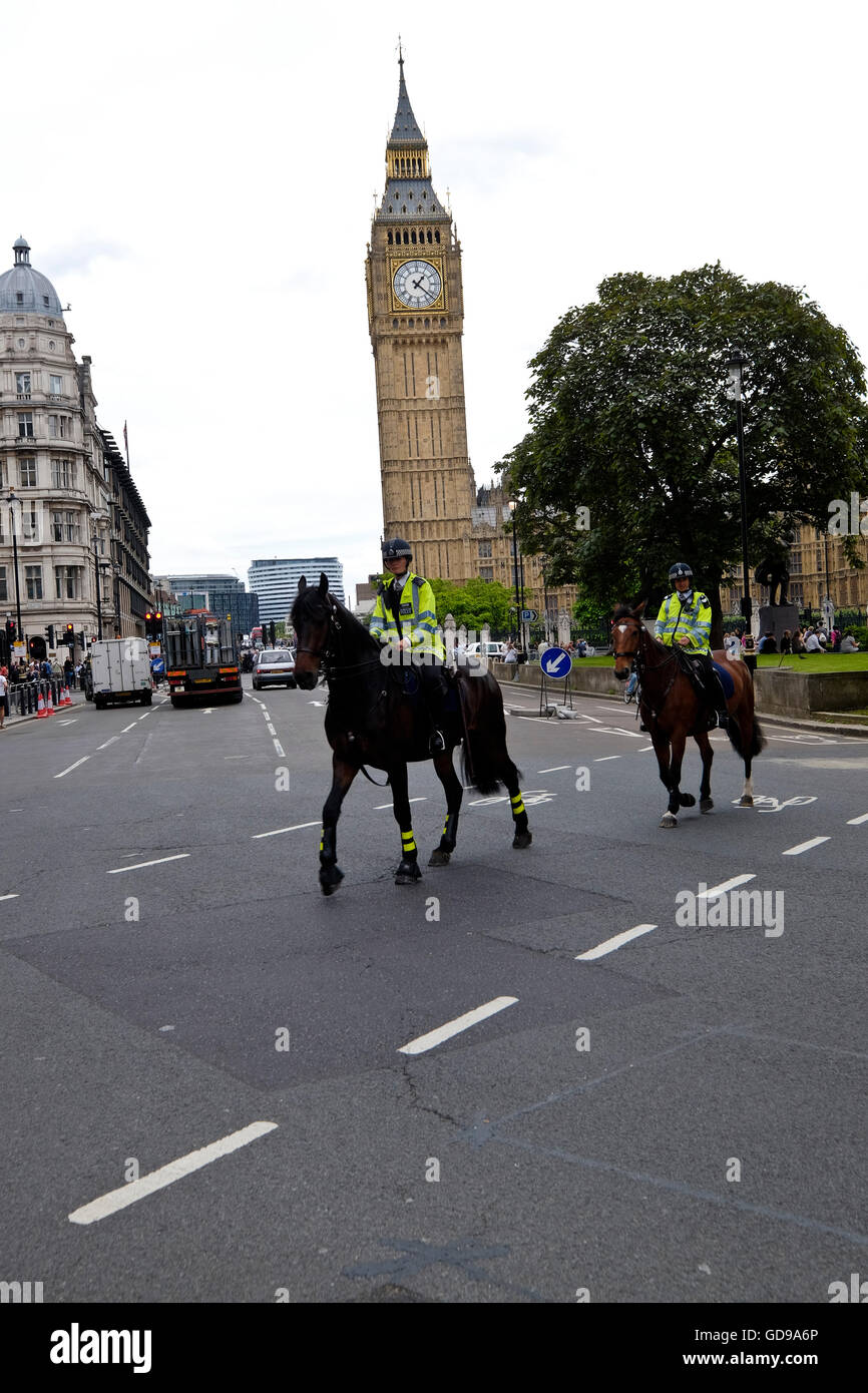 Montados en las patrullas de la policía británica, cerca de la Plaza del Parlamento con el Big Ben de Londres un hito en el fondo Foto de stock