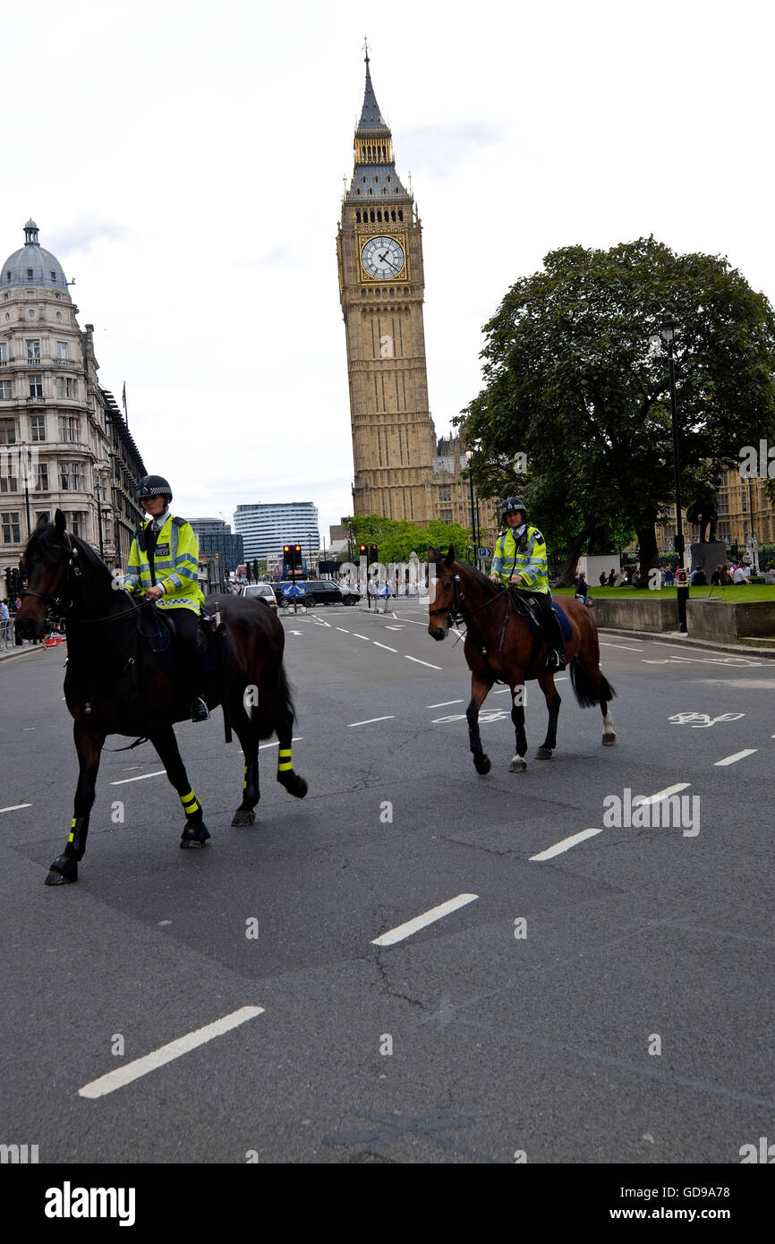 Montados en las patrullas de la policía británica, cerca de la Plaza del Parlamento de Londres con el Big Ben de Londres un hito en el fondo Foto de stock