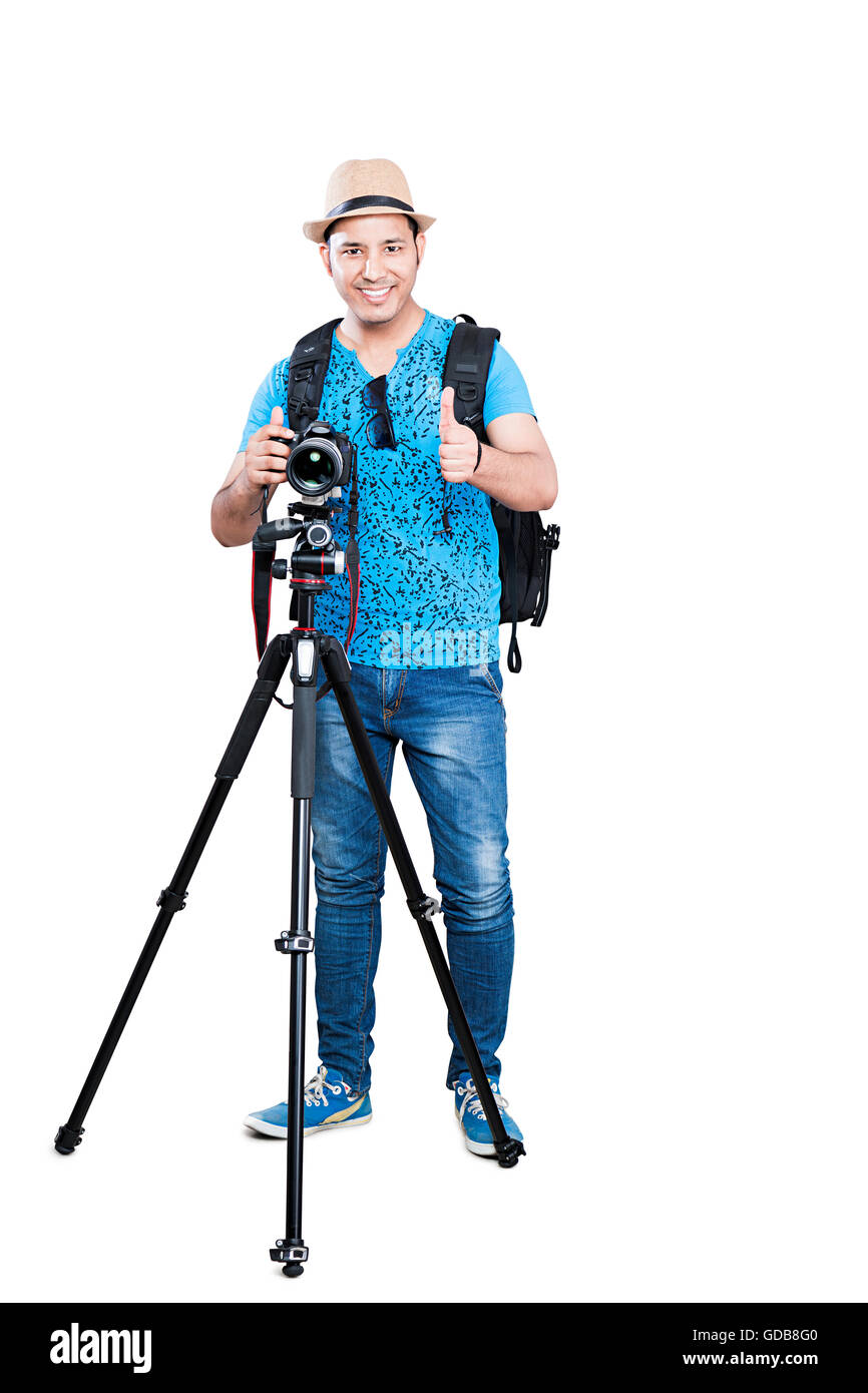 Uno indio sonriente camarógrafo fotógrafo con trípode de la cámara haciendo  clic en la imagen y la afición mostrando Thumbs up Fotografía de stock -  Alamy