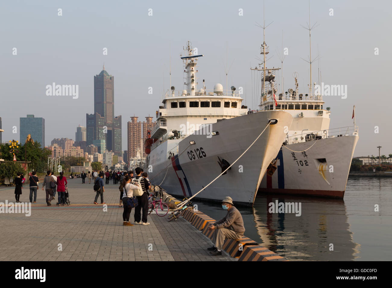 Kaohsiung, Taiwán - Enero 11, 2015: la gente en la parte frontal del puerto con los barcos anclados Foto de stock