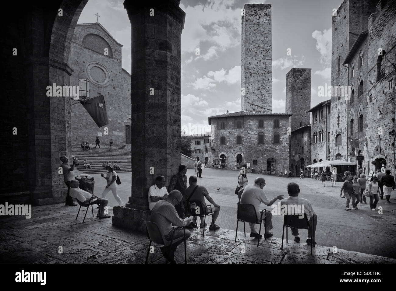 Provincia de San Gimignano, Siena, Toscana, Italia. Los lugareños relajante en la Piazza del Duomo. Foto de stock
