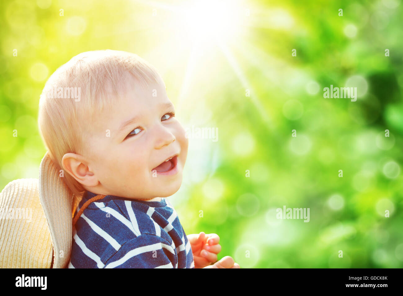 Baby Boy sentado en la hierba en las fieald con diente de león Foto de stock