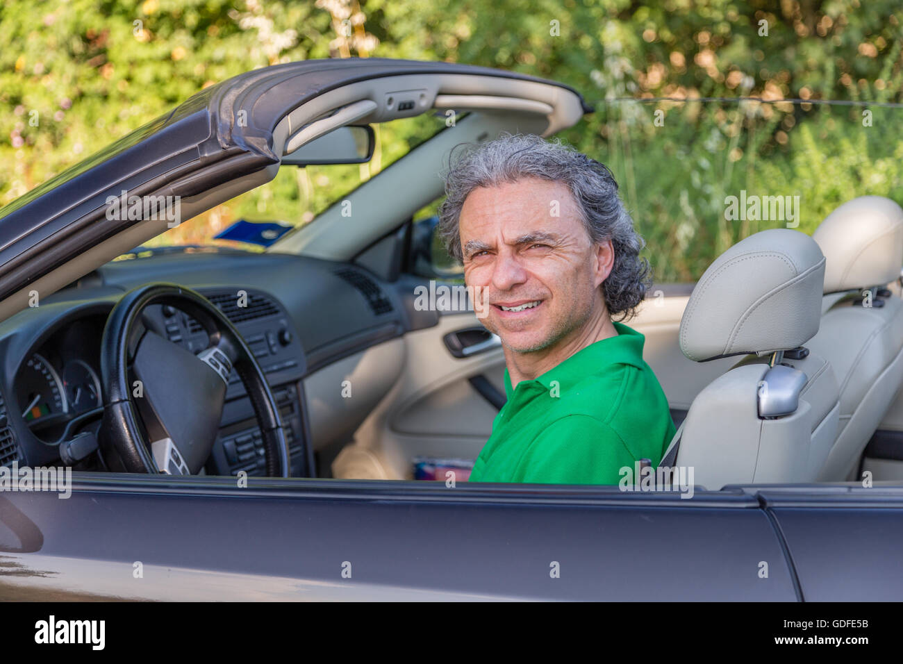 Hombre maduro conduciendo un coche convertible está desconcertado y perplejo Foto de stock