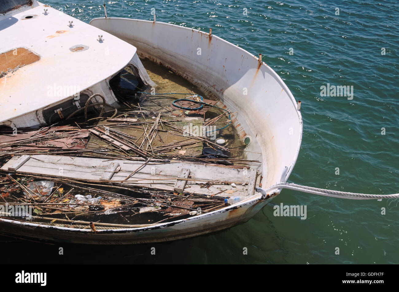 Barcos amarrados en el puerto hundido lleno de residuos Closeup Foto de stock