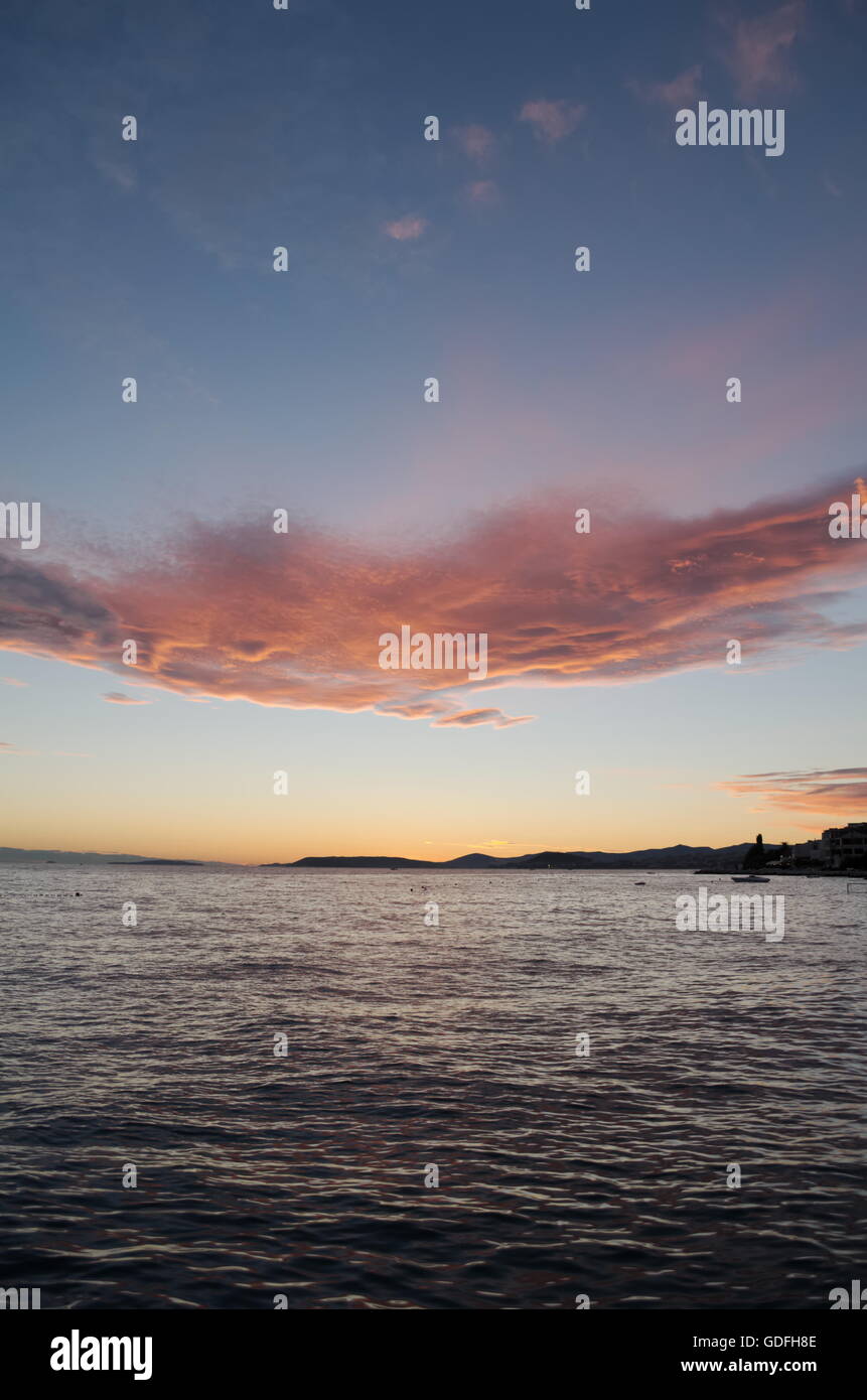 Atardecer en Split, Croacia con mar tranquilo y mágico Vertical nubes Foto de stock