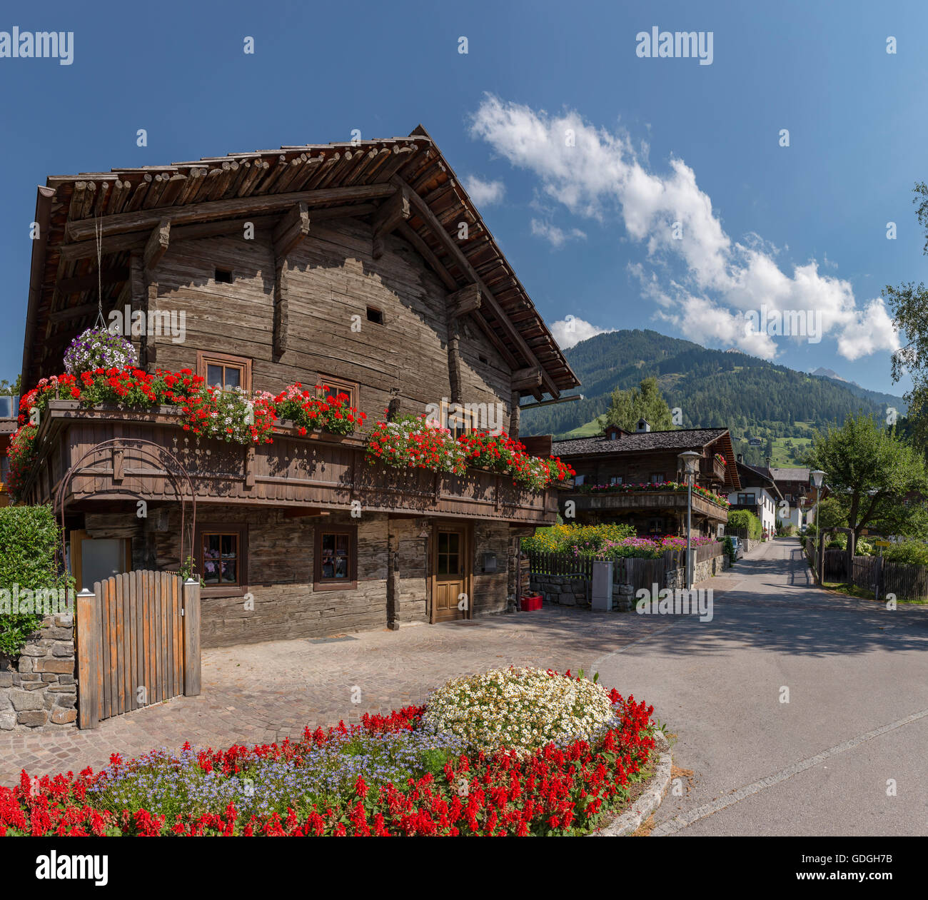En Osttirol Matrei,Austria,antiguas casas de madera con jardineras en la Pattergasse Foto de stock