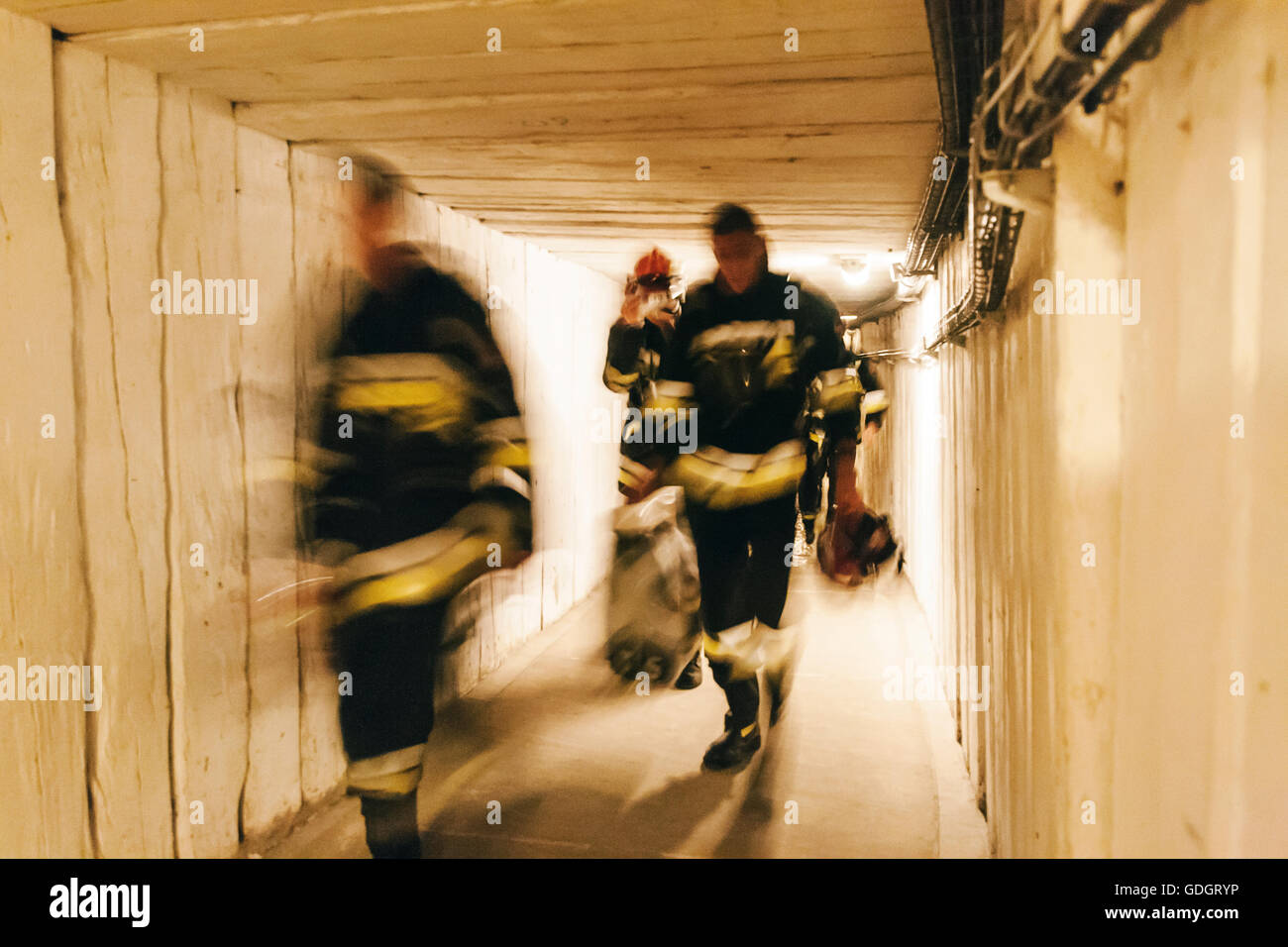 Tres bomberos polaco cansado borrosa túnel mina caminando Foto de stock