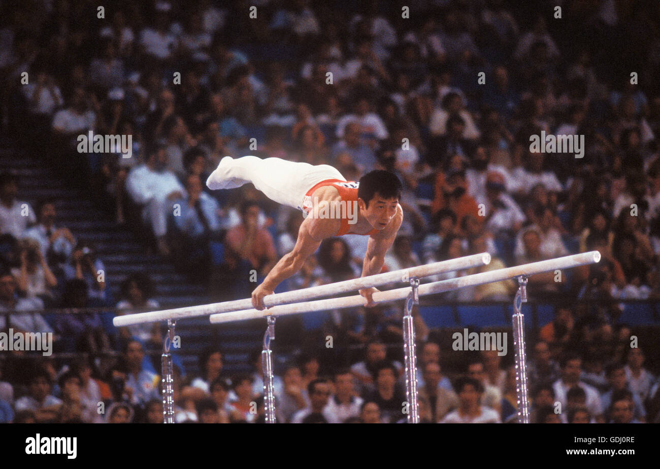 Gimnasta chino realiza en barras paralelas en los Juegos Olímpicos de 1984 en Los Ángeles. Foto de stock