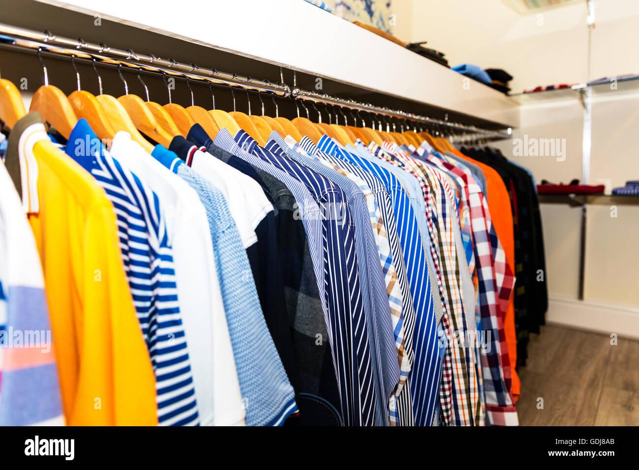 Dos grados límite vendedor Camisetas en la tienda de ropa en perchas mostrar Mostrar fila de camisas  para hombres a elegir la camiseta en Hanger UK Inglaterra Fotografía de  stock - Alamy