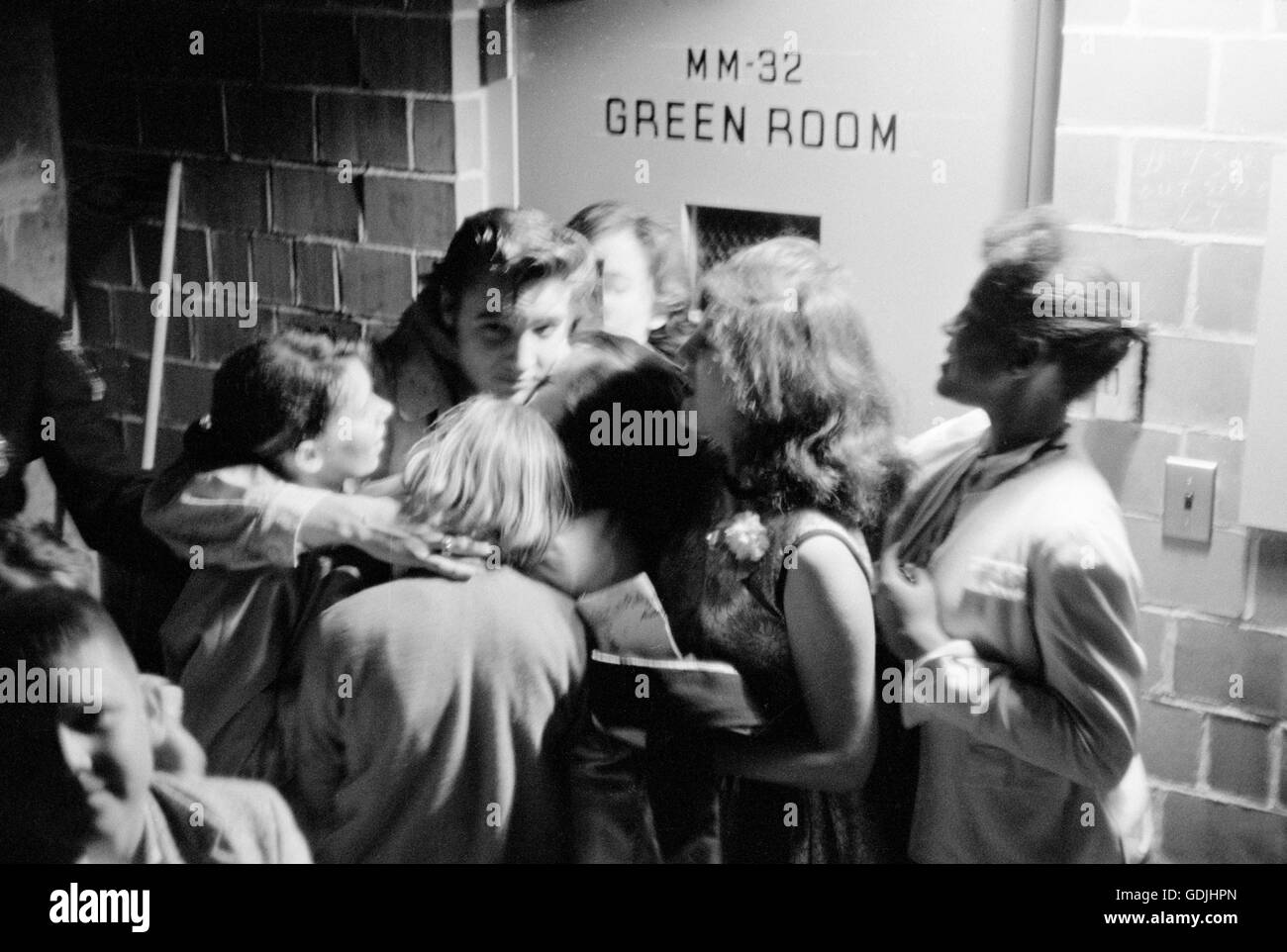 Elvis Presley abrazar a un grupo de fanáticos, backstage después de una actuación en la Universidad de Dayton Fieldhouse, 27 de mayo de 1956. Foto de stock
