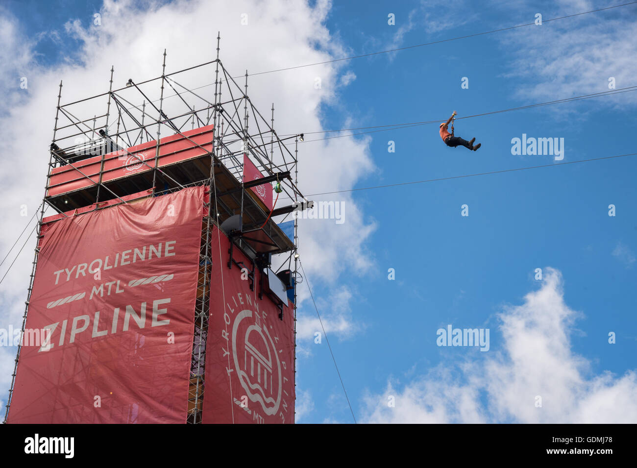Un hombre está montando MTL zipline en el Viejo Puerto de Montreal. Foto de stock