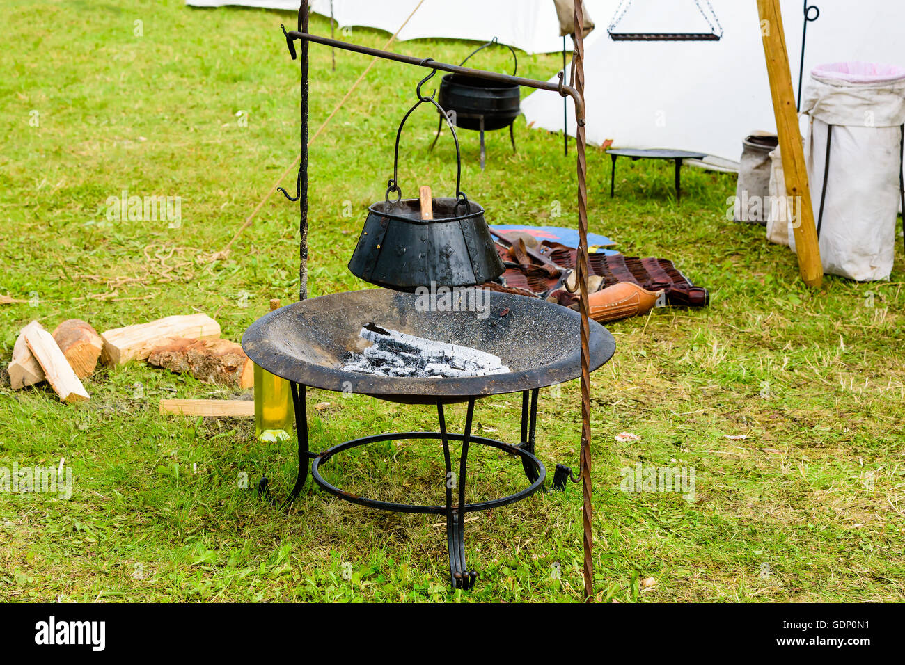 Olla exterior pende sobre madera quemada y cenizas. Pot está ennegrecido  artesanales de hierro con remaches Fotografía de stock - Alamy