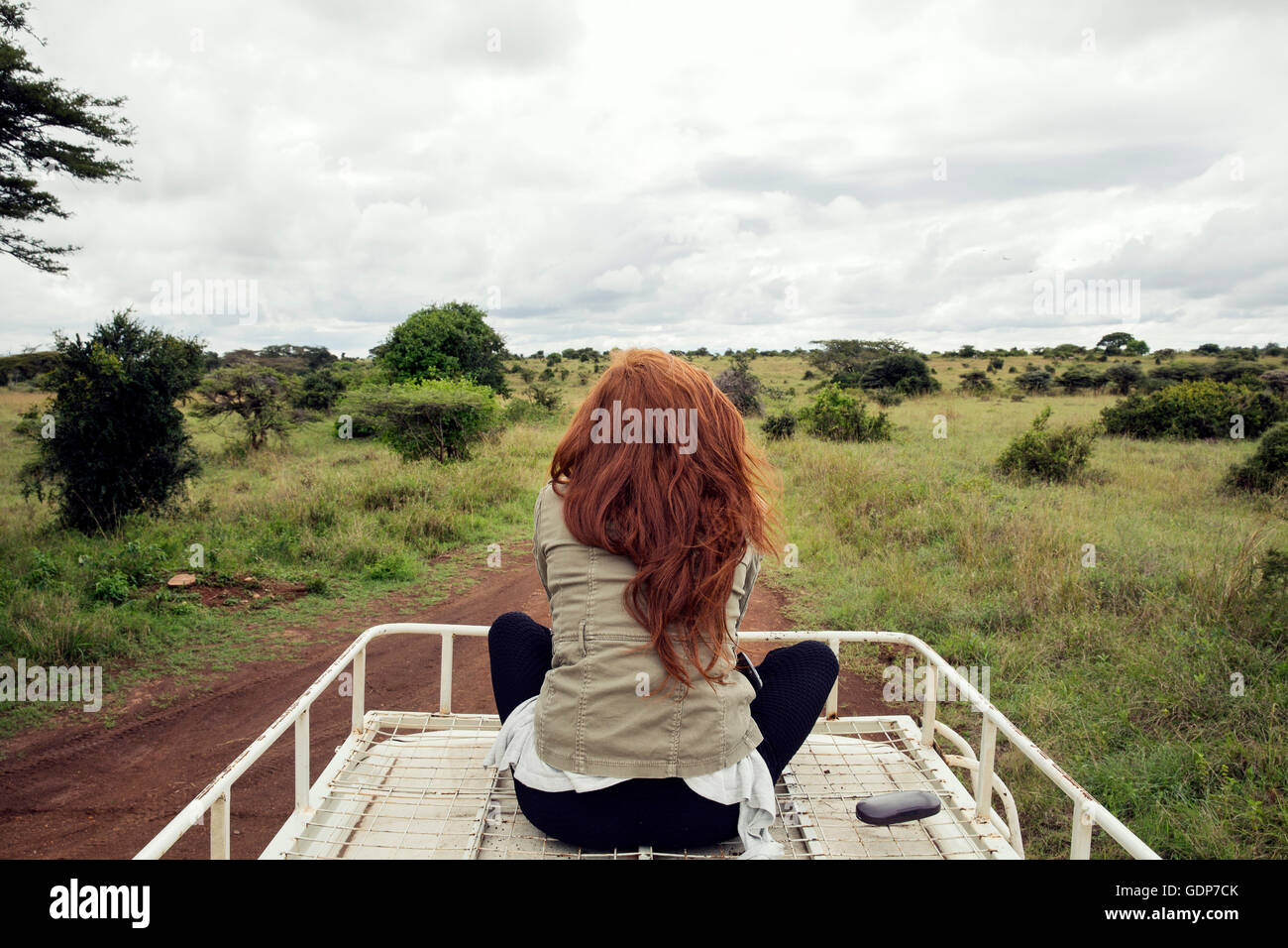 La mujer disfruta de viajar encima del vehículo en Wildlife Park, Nairobi, Kenia Foto de stock