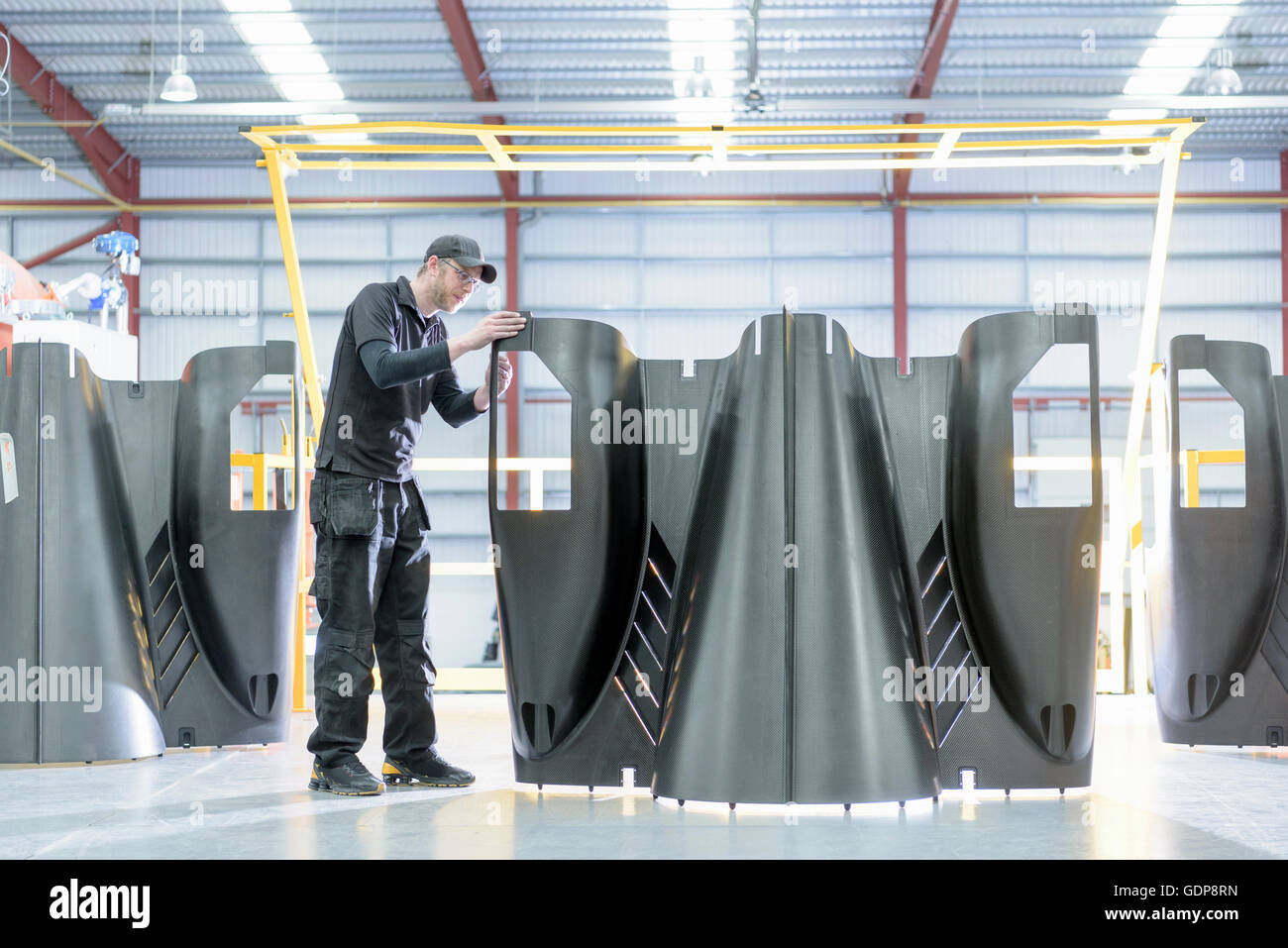 Ingeniero de fibra de carbono de las partes del cuerpo de inspección en fábrica de coches de carreras Foto de stock