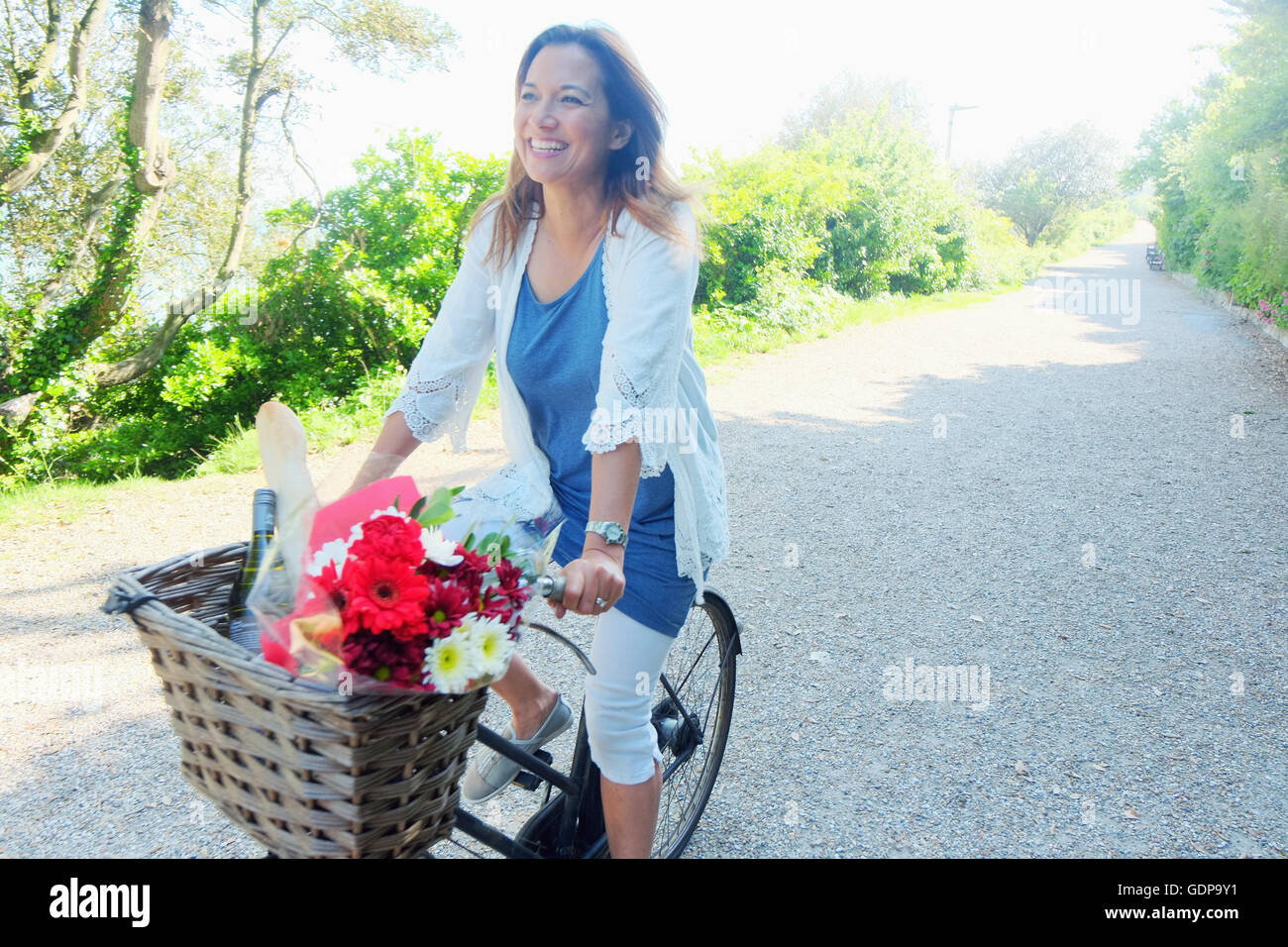 Mujer en bicicleta mirando lejos sonriendo Foto de stock
