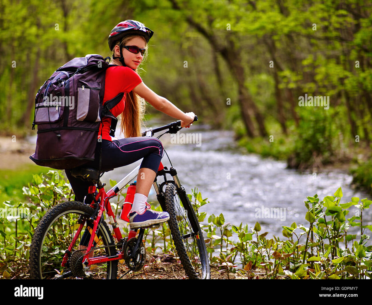 Chica con gran mochila de bicicletas ciclismo vadear a través de agua  Fotografía de stock - Alamy