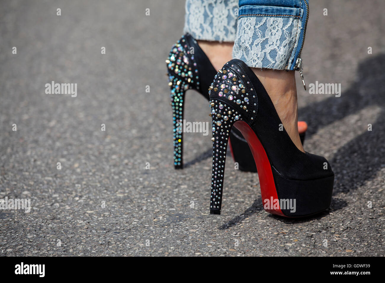 Jeans vestidos de mujer pies con tacones altos zapatos suela roja Fotografía - Alamy