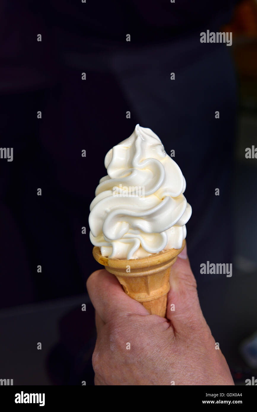 Mano sujetando suave servir helado de vainilla Foto de stock