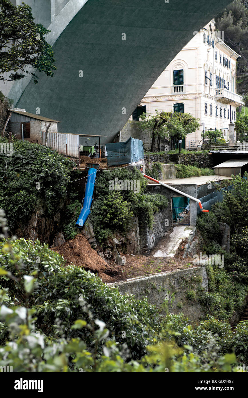 Pequeña casa bajo un puente carretero de la serie de fotos "otto l'autostrada' en Liguria, Italia, 2012 Foto de stock