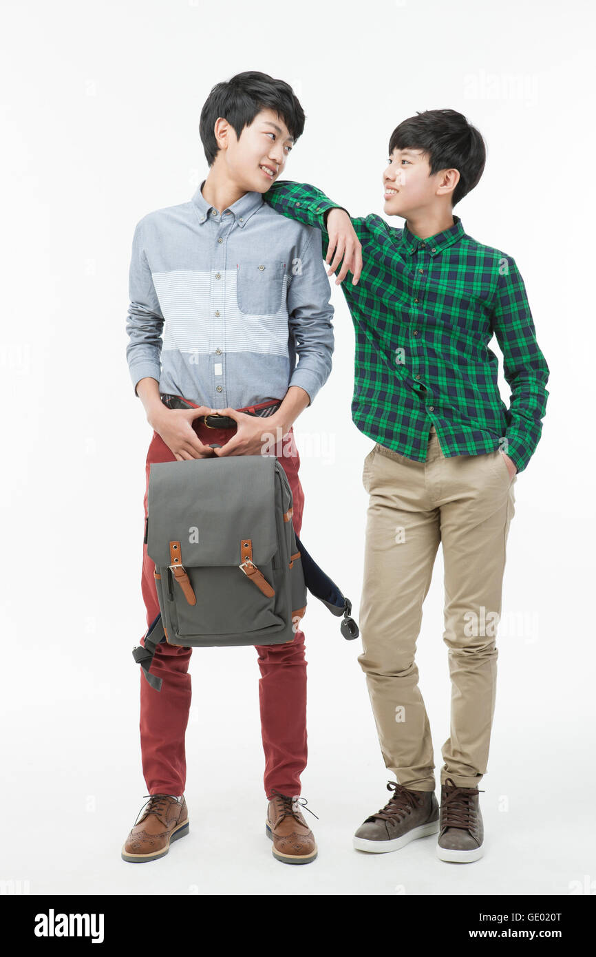 Dos chicos de escuela coreana sonriente en ropa casual con mochila de pie  frente a frente Fotografía de stock - Alamy