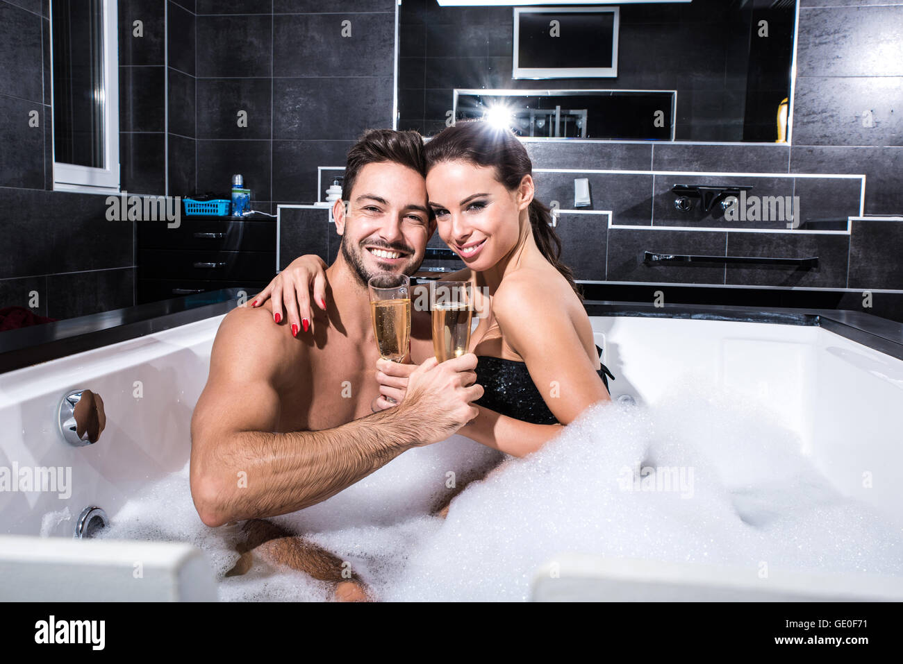 Hermosa pareja joven relajándose juntos y beber champán en el jacuzzi Fotografía de stock - Alamy Hermosa pareja joven relajándose juntos y beber champán en el jacuzzi Fotografía de stock - Alamy