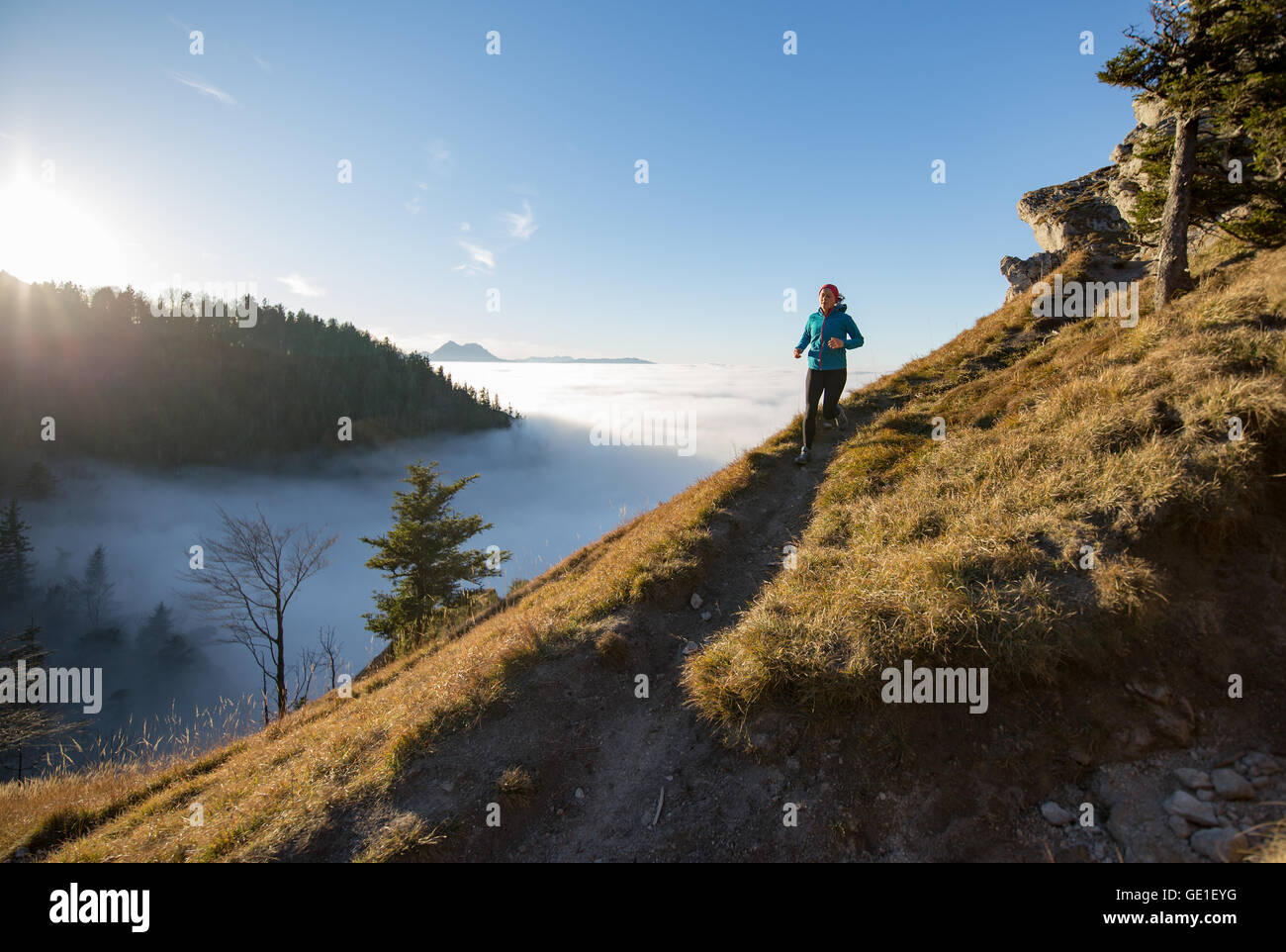 Mujer Trail Running en las montañas por encima de las nubes, Salzburgo, Austria Foto de stock