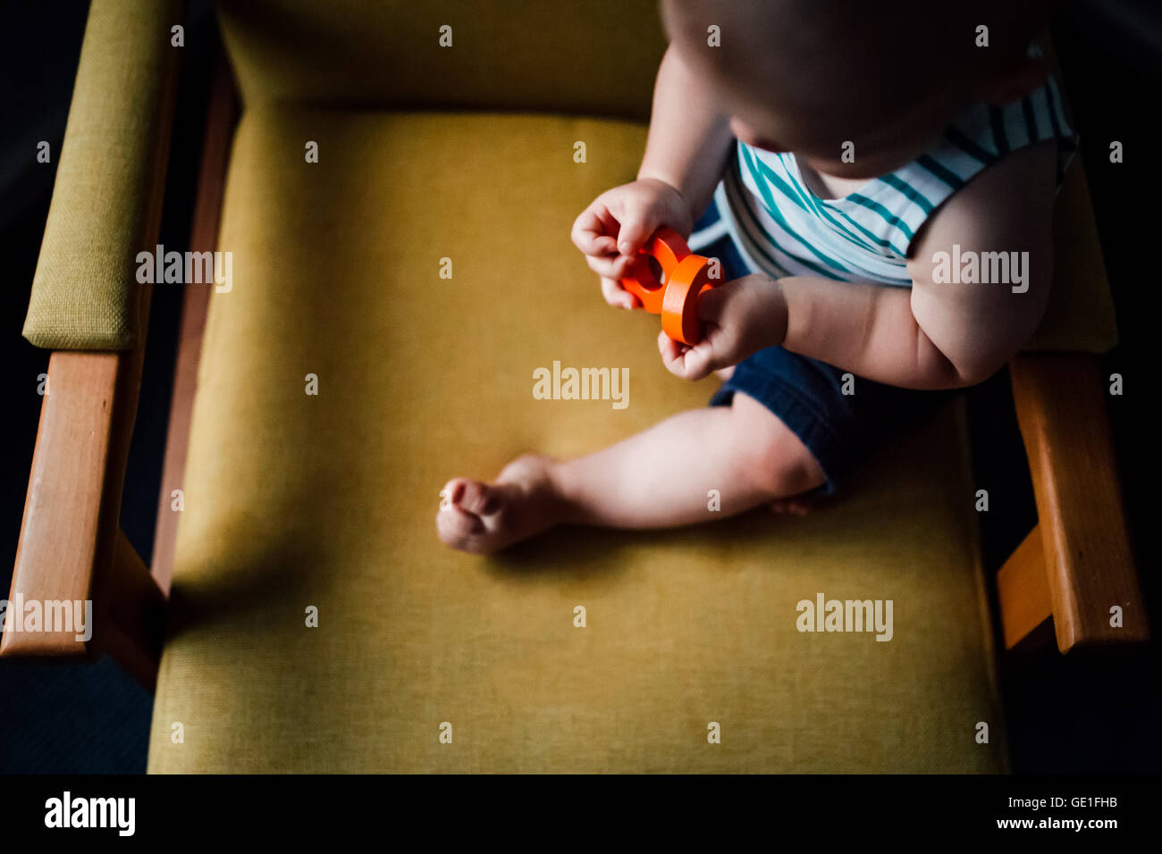 Baby Boy sentado en una silla jugando con bloques Foto de stock
