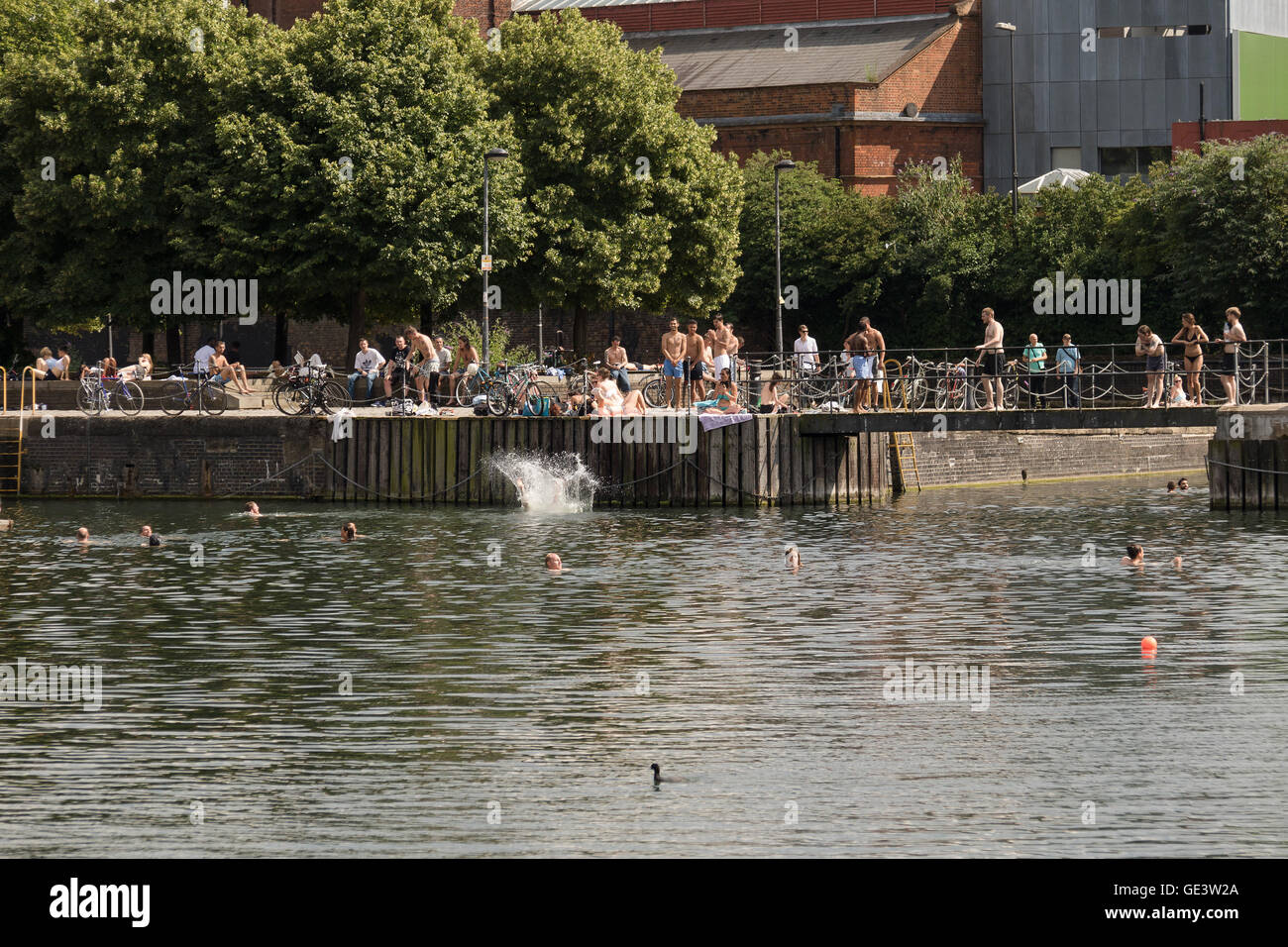 Personas disfrutando del agua fría durante un clima cálido y soleado en la cuenca  de Shadwell en East London esta tarde. Personas han sido advertidos para no  nadar en Cuenca Shadwell tras