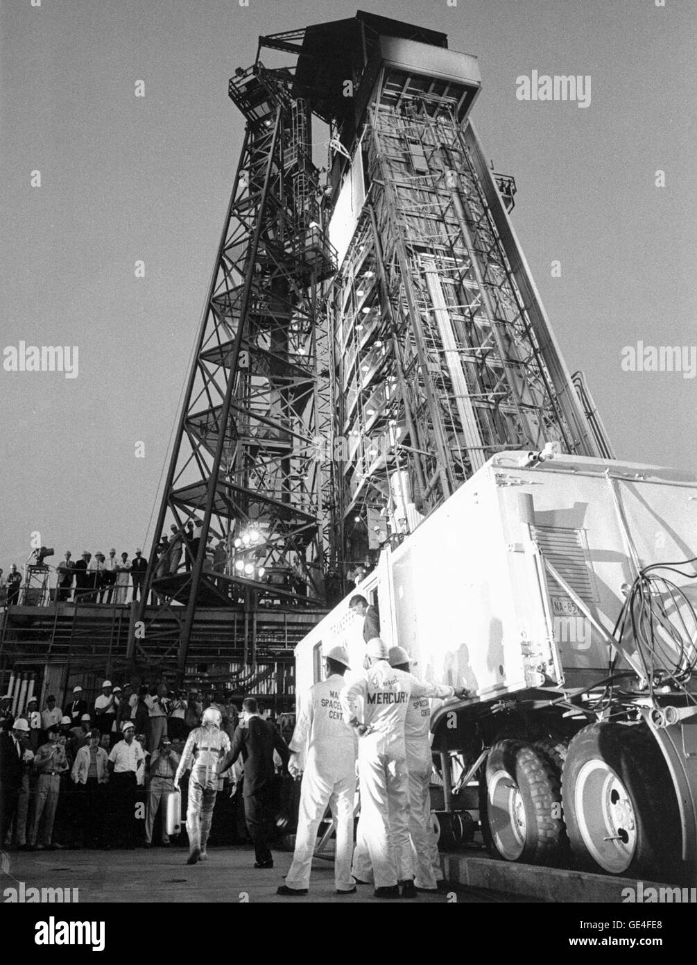 El astronauta Gordon Cooper, partiendo de la transferencia van en su traje y el casco de presión de plata, es saludado con aplausos de los reunidos Pad 14 empleados. Cuando llega a la base de la torre de servicio, él andará en un ascensor hasta donde su nave espacial Mercury apodada "la fe 7" espera su llegada. Imagen # : 63-MA9-132 Mayo 15, 1963. Foto de stock