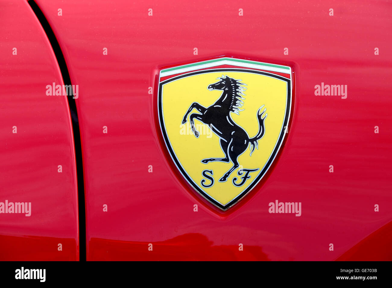 Un primer plano de una insignia de Ferrari en un coche Ferrari rojo. La imagen muestra la cresta de caballo prancing familiar del fabricante de automóviles italiano Foto de stock
