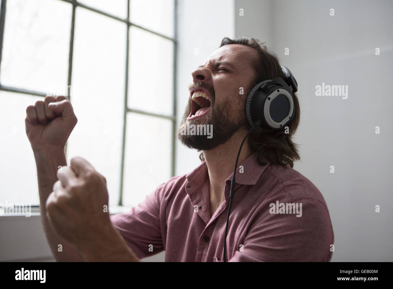 Hombre con auriculares cantando música Foto de stock