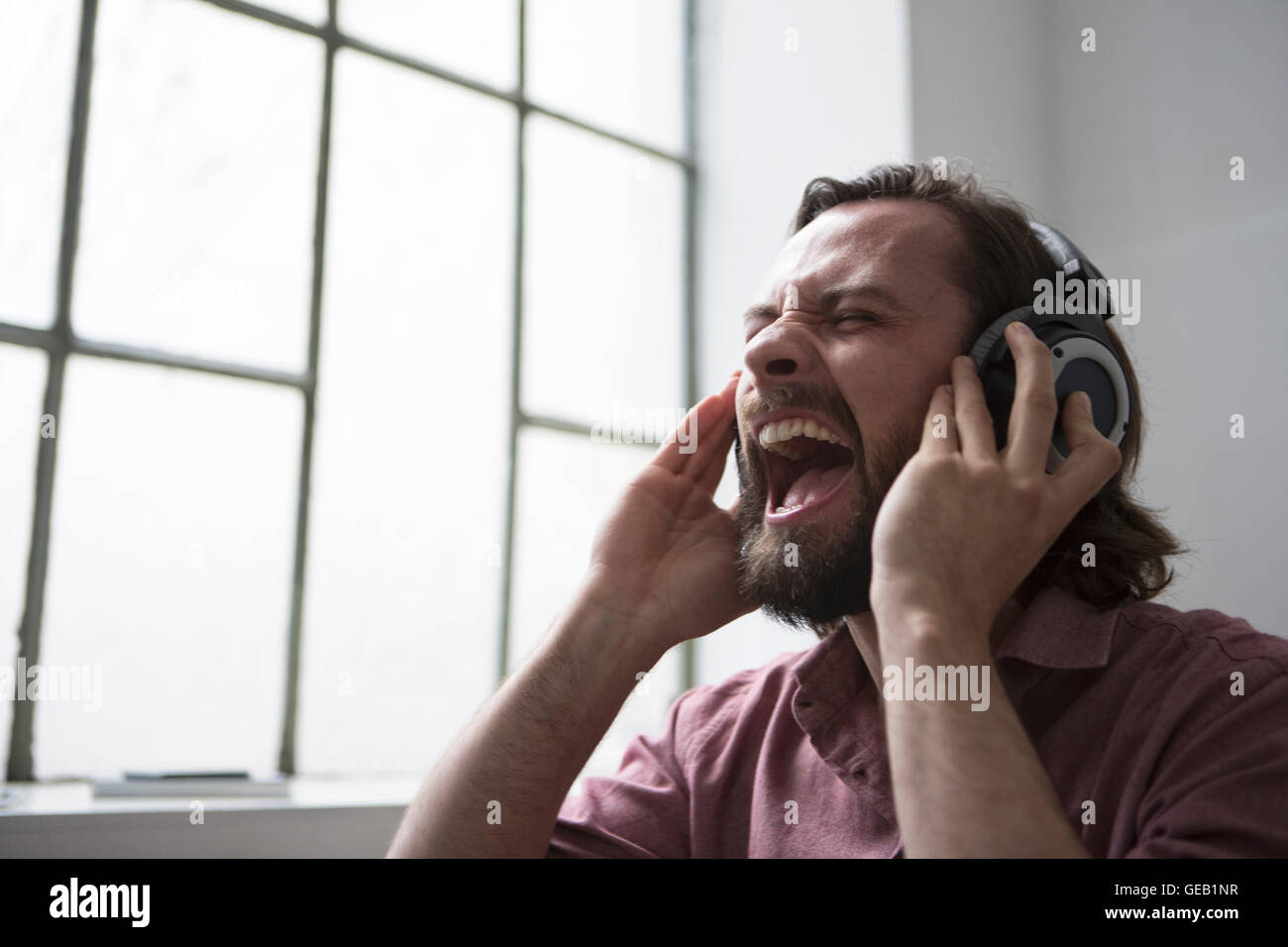 Hombre con auriculares cantando música Foto de stock