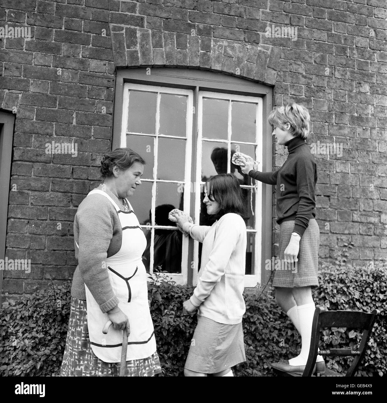 Alumnas escolares niñas que ayudan a residentes mayores en Madeley, Shropshire, FOTO DE la década de 1960 POR DAVID BAGNALL Foto de stock