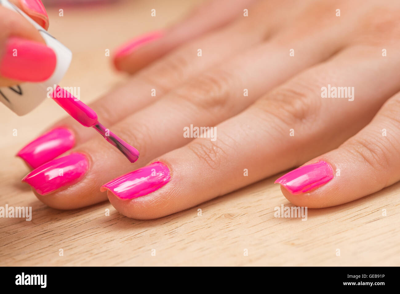 De cerca una mujer rosa pintura Laca de uñas en sus uñas Foto de stock