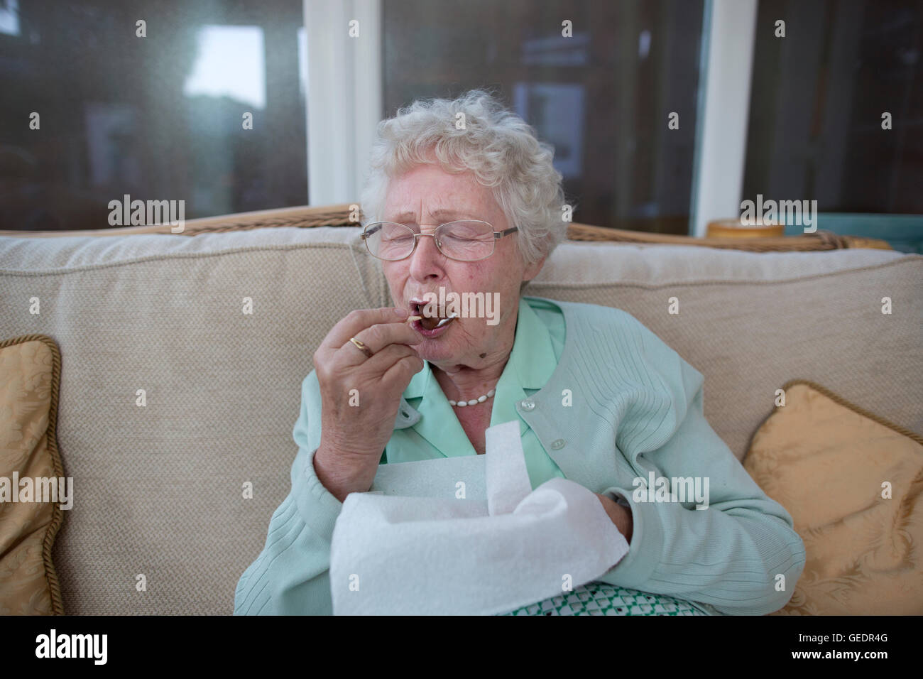Viejo pensionista disfrutando un helado mientras vivían solos en Inglaterra, Reino Unido Foto de stock