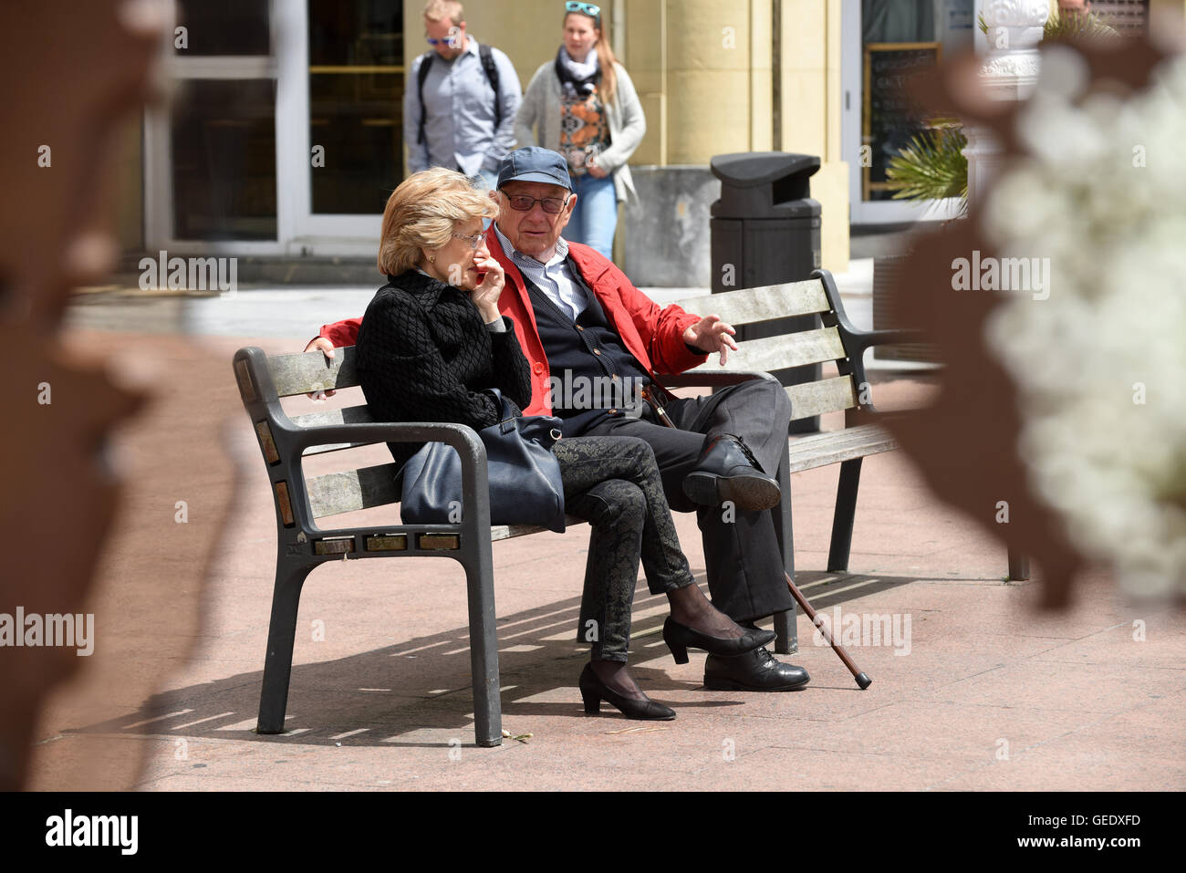 Hombre y mujer pareja sentada sobre la banqueta pública‡n San Sebastián Donostia Spain Foto de stock