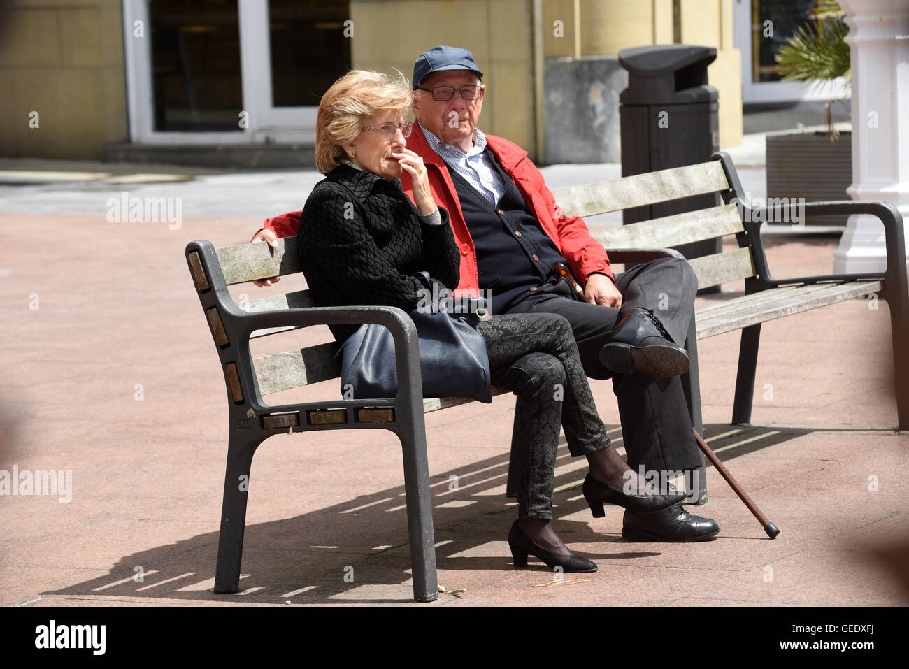Hombre y mujer pareja sentada sobre la banqueta pública‡n San Sebastián Donostia Spain Foto de stock
